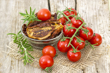 fresh and dried tomatoes on wooden background