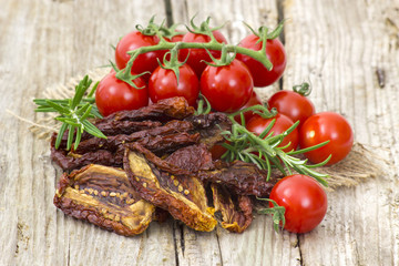 fresh and dried tomatoes on wooden background