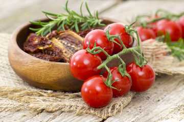 fresh and dried tomatoes on wooden background