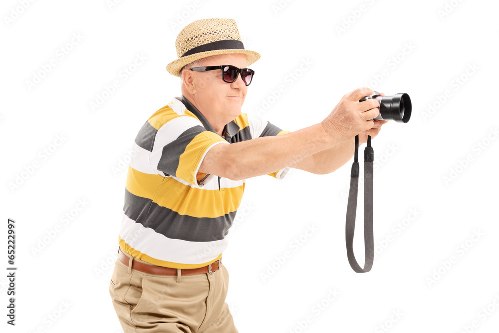 Wall mural mature tourist taking a picture with camera