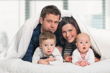 Obraz premium Happy family with children in bed
