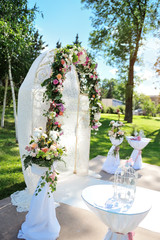 Decorated archway for wedding ceremony with colorful flowers and