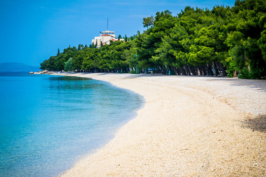 Beautiful azure blue Mediterranean beach surrounded by trees