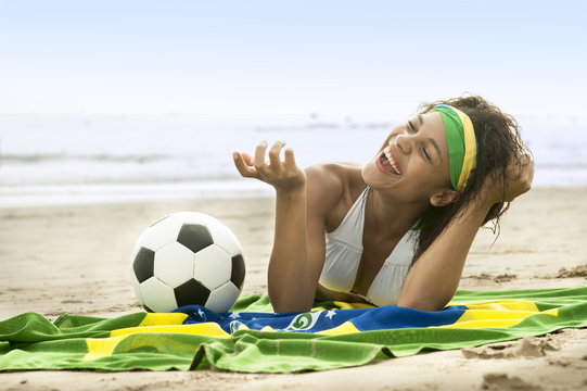 young attractive brazil supporter on beach with Brazil flag