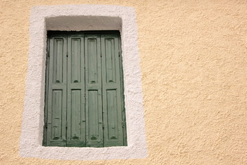 green painted wood Mediterranean Shutters set in pink wall