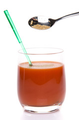 Celery salt falling into a glass of tomato juice