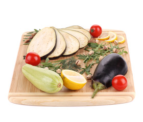 Vegetables with pistachios on wooden platter.