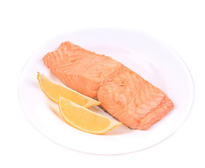 Fried salmon fillet on plate with lemon.
