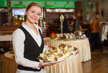 Catering service employee or waitress with a tray of appetizers