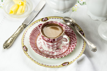 Antique porcelain breakfast setting with white coffee on white c