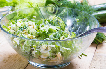 salad with fresh vegetables in glass bowl on the  table