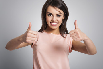 Smiling lovely woman showing thumbs up