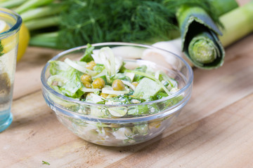 salad with fresh vegetables in glass bowl on the  table