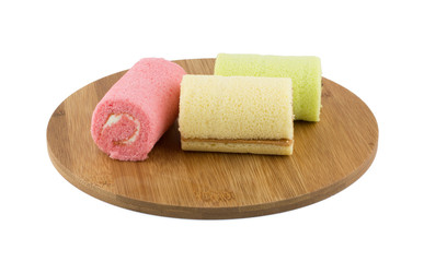 Colorful roll cake on wooden plate