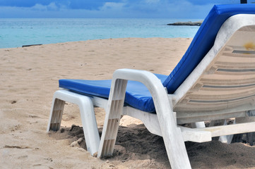 blue deck chairs in front of beach
