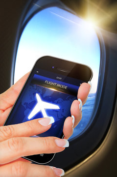 Hand Holding Mobile Phone With Flight Mode In The Airplane