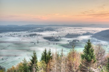 Sunrise above fields covered with morning mists