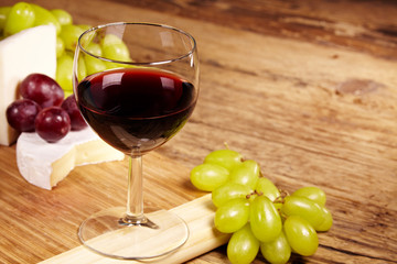 A red glass of wine and cheese