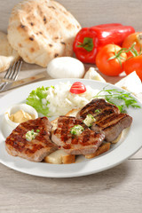 Grilled steaks on toast bread, served with onion and vegetable