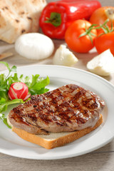 Grilled steak on toast bread, served with onion and vegetable