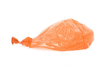 Deflated orange balloon isolated over white