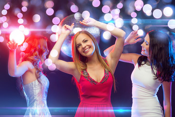 three smiling women dancing in the club