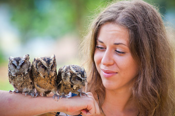 girl holding on a hand of beautiful owls