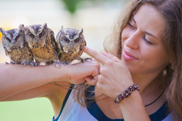 girl holding on a hand of beautiful owls