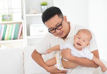 Obraz na płótnie Canvas Asian family lifestyle at home. Father flying baby boy, having f