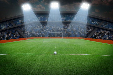 Soccer ball on field in stadium at night