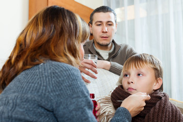  parents giving medicinal sirup to teenage