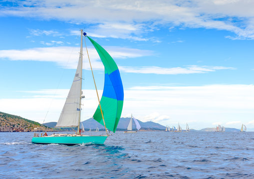 Sailing boat with a green blue spinnaker Poros island Greece