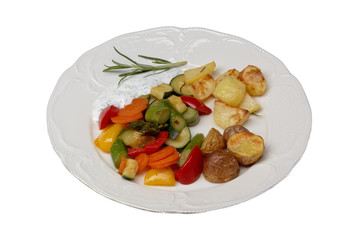 isolated plate with vegetables and oven potatoes