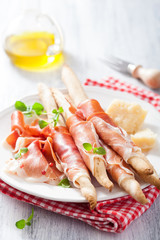prosciutto ham and grissini bread sticks. italian antipasto