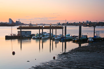 Fototapeta premium Boats on river Thames and flood barrier in the distance.