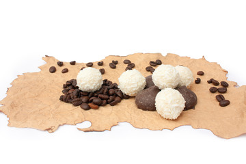 candys and grains of coffee on a singed paper