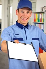 Smiling delivery man, holding clip board and carton box