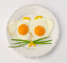 white plate with two fried eggs isolated on white background