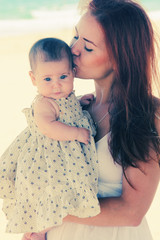 Portrait of happy loving mother and her baby at the beach