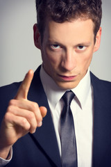 Portrait of a angry businessman, pointing finger.