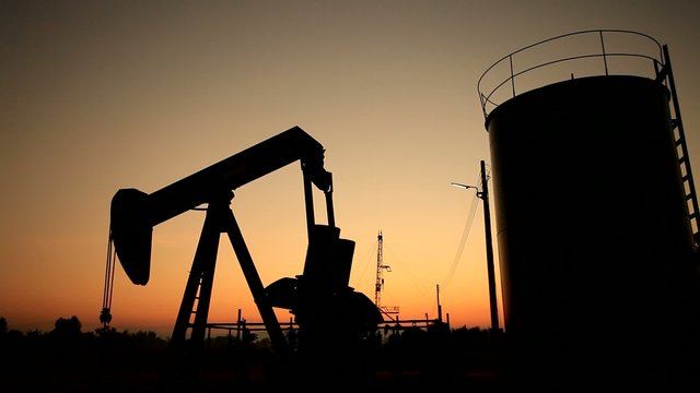 Silhouette Moving Oil Pumpjack (Sucker Rod Beam) at Sunset Time