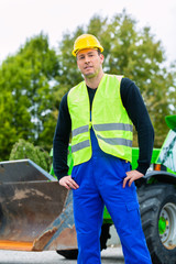 Bauarbeiter vor Baumaschine einer Baustelle