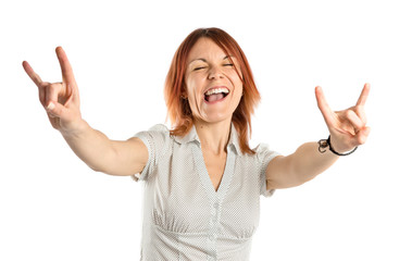 Young girl doing horn gesture over white background