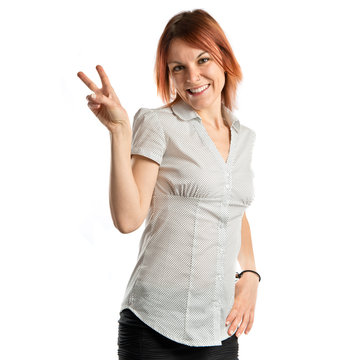 Young woman doing victory gesture over white background