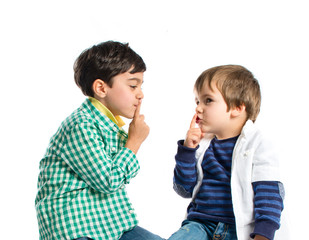 Kids doing silence gesture over white background
