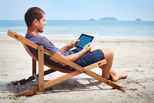 business man working with tablet on the beach