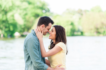 Fototapeta premium Young couple outdoors, near lake. hugging and havving a good time