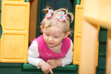 Little child girl playing in kindergarten in Montessori