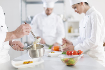 Fototapeta na wymiar anonymous hands preparing food in professional kitchen
