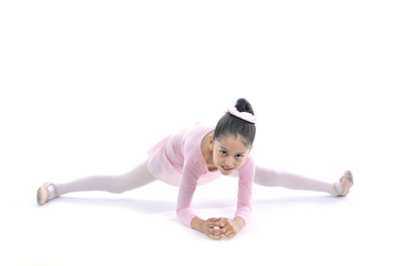 young cute Ballerina girl stretching wearing pink Ballet tutu